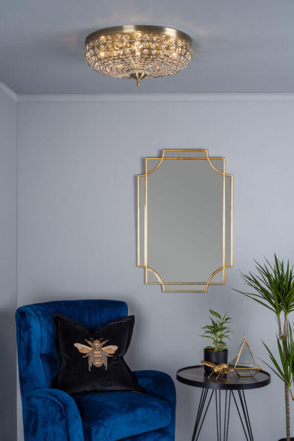 An antique brass flush mounted fixture with crystal beading displayed in a living room setting